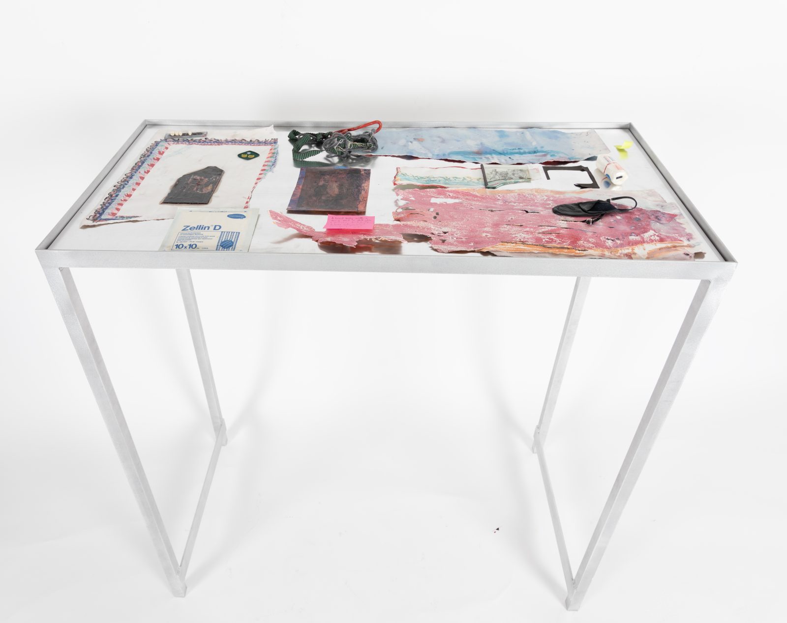 Various found object and drawings on aluminium table